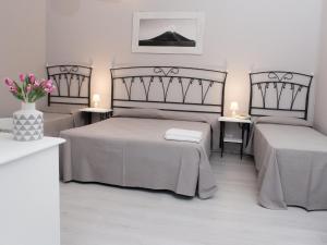 坎内托Pietra Pomice Hotel的一间卧室设有两张床和花瓶