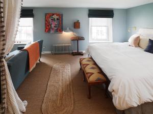 伍德斯托克皇冠酒店的一间卧室设有一张大床、一把椅子和窗户。
