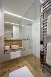 布拉格金星酒店的一间带玻璃淋浴和水槽的浴室