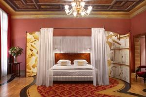 威尼斯萨图瑞尼亚国际酒店的一间卧室配有一张带白色窗帘和吊灯的床。