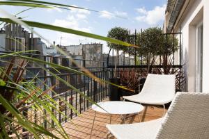 巴黎莫利亚酒店的阳台配有2把椅子和1张桌子