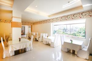 台北丽之汤温泉会馆的餐厅设有白色的桌椅和大窗户