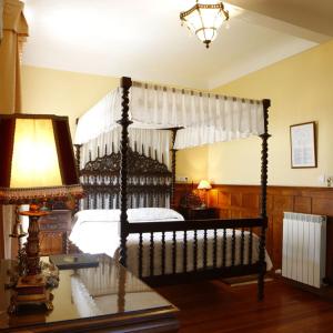 Cefontes昆陀杜罗酒店的一间卧室配有一张天蓬床和一张带台灯的桌子