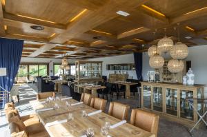 科菲诺Puebloastur Eco Resort Hotel & Spa的餐厅设有木制天花板和桌椅