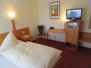 格奥尔格斯马林许特若斯酒店的酒店客房配有一张床和一张书桌及一台电视