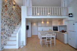 法里拉基卡塔拉湾公寓酒店的厨房设有楼梯和桌椅