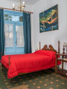 坦迪尔Casa Chango Hostel的一间卧室配有一张红色的床和蓝色的门