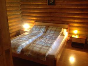 豪伊杜索博斯洛Relax Apartman的木间内的一张床位,配有两盏灯