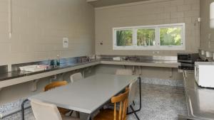 派西亚怀唐伊假日公园酒店的厨房配有白色的大桌子和椅子