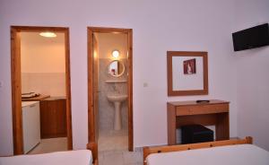 帕拉利亚卡泰里尼斯Giannis Hotel的一间带水槽、卫生间和镜子的浴室