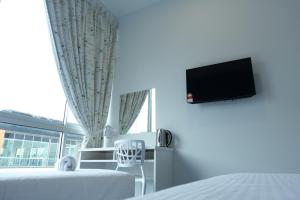 芙蓉洛奇10号酒店的一间卧室设有一张床、一台电视和一个窗口。