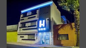 阿里卡Le Prince Arica的白色的建筑,上面有蓝色 ⁇ 虹灯标志