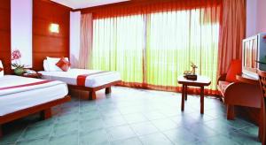 华欣华欣阁楼酒店的酒店客房设有两张床、一张桌子和一台电视。