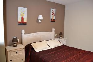 阿尔巴拉辛罗斯派洛斯欧酒店的卧室配有白色的床和2个床头柜