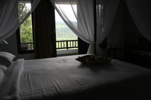 姆杜克普瑞阿拉姆巴厘酒店的卧室配有白色的床和窗户