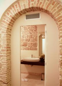 阿斯科利皮切诺阿尔伯格桑特艾米蒂欧酒店的拱门通往带水槽的浴室