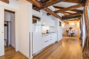 威尼斯威尼斯救赎节公寓的厨房配有白色橱柜和木制天花板。