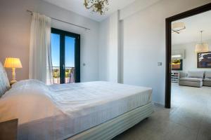 斯沃伦塔Seirios Luxury Villa的一间白色的卧室,配有一张大床和一个客厅
