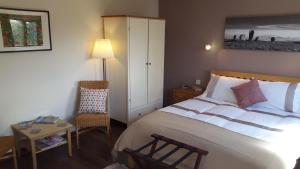 MilfieldPantile Lodge的一间卧室配有一张床、一把椅子和一张桌子