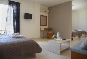 锡蒂亚海风酒店的一间卧室配有一张床、一张沙发和一台电视。