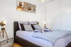 图卢兹Séjour Toulouse Purpan Le D'este的一间卧室配有一张带蓝色毯子和枕头的床。