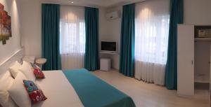 伊斯坦布尔Payidar HOTEL的一间卧室配有一张带绿色窗帘的床和电视。