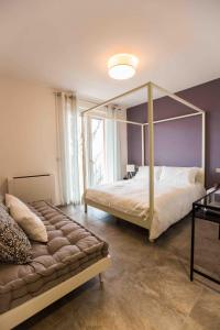 福萨诺Cascina Belmonte的一间卧室设有一张天蓬床和大窗户