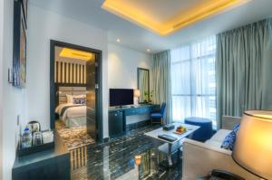 迪拜Signature 1 Hotel Tecom的酒店客房设有床和客厅。