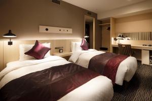 仙台仙台远景酒店的酒店客房 - 带两张带红色枕头的床