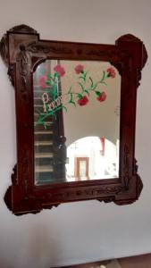 圣玛丽亚港卡萨得瑞多酒店的挂在墙上的镜子,上面有鲜花