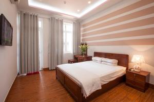 美奈芳南旅馆的一间卧室配有一张带条纹墙的床