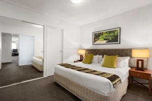 墨尔本魁克斯特奥利蒙酒店的配有一张大床和镜子的酒店客房