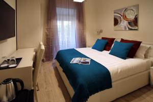 罗马CdR旅馆的一间卧室配有一张带蓝色枕头的大床