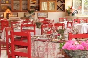 洛萨达Casa de Juste的用餐室配有红色椅子和桌子及酒杯