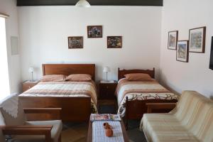 卡洛帕尼亚伊奥蒂斯爱普拉提亚酒店的一间卧室配有两张单人床和一张沙发