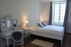 圣马洛圣马洛1685庄园酒店的白色卧室配有床、书桌和镜子