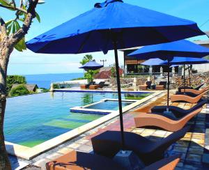 艾湄湾巴厘岛布瓦纳别墅的游泳池旁的游泳池配有椅子和遮阳伞