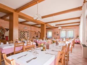 阿维奥Albergo Alpino da Tullio的用餐室配有白色的桌子和木椅