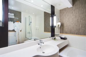 赫尔辛基赫尔辛基市中心假日酒店的白色的浴室设有水槽和镜子