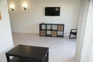 阿尔沃尔Vila da Praia 7D Alvor的客厅配有黑桌和电视。