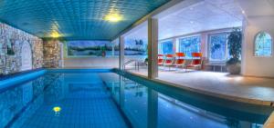 科拉尔博喜博格乐酒店的游泳池,位于带红色椅子的房子里