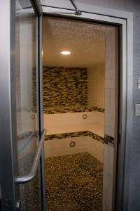 梅迪辛哈特Ramada by Wyndham Medicine Hat的浴室设有步入式淋浴间,位于玻璃门旁