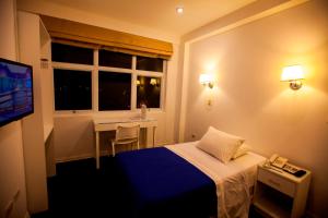 万卡约万卡约帕尔马酒店的酒店客房设有床、桌子和窗户。