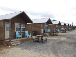 StockdaleAll Tucked Inn Cabins的一排带蓝色桌椅的木制小屋