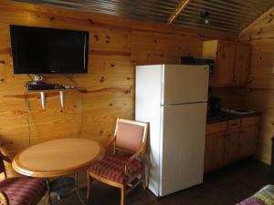 StockdaleAll Tucked Inn Cabins的厨房配有小桌子和冰箱。
