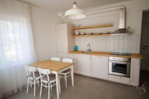 特罗吉尔Apartments Terra Petrosa的厨房配有木桌和白色橱柜。