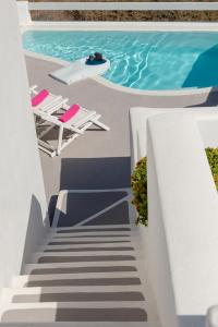 阿克罗蒂里Aura Marina Apartments Santorini的通往带椅子的游泳池和游泳池的楼梯