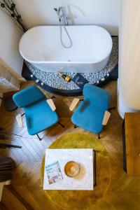 扎达尔DeZign Superior Apartments & Rooms的带浴缸、两把椅子和一张桌子的浴室