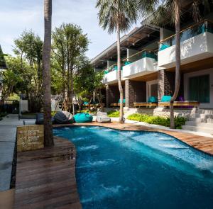 七岩班恩班底度假酒店的一座楼前棕榈树游泳池