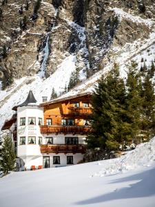 皮茨河谷圣莱昂哈德阿尔霍夫雷特夫匹兹塔尔旅馆的山前雪中建筑物